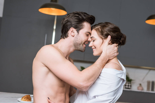 stock-photo-adult-man-woman-smiling-embracing-kitchen.jpg