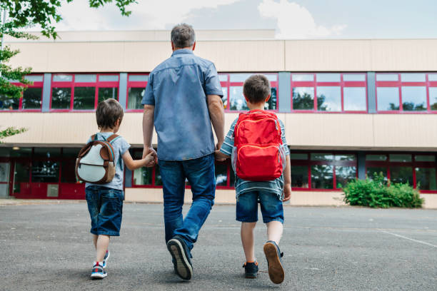 Père emmenant ses enfants à l'école